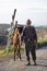 A senior turkish man with torn clothes is carrying cargo on his horse