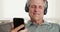 Senior using smartphone listening to music