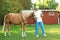 Senior veterinarian with clipboard near palomino horse