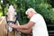 Senior veterinarian examining palomino horse on sunny day