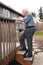 Senior walks up wooden deck steps outside