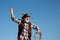 Senior western cowboy throwing lasso rope. Bearded wild west man with brown jacket and hat catching horse or cow. Rodeo