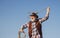 Senior western cowboy throwing lasso rope. Bearded wild west man with brown jacket and hat catching horse or cow. Rodeo