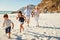 Senior white couple and their grandchildren walking on a sunny beach, close up