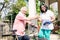 Senior wife giving a bottle of water to her husband after cycling