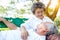 Senior wife looks at her mature husband with love and smile face, happiness. Elderly man rest on older wife`s laps at park. Old co