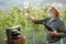 Senior winemaker with wineglass and press machine on the vineyard