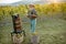 Senior winemaker with wineglass and press machine on the vineyard