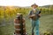 Senior winemaker with wineglass and press machine on the vineyard