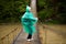 Senior woman 60 years old Crossing River by hinged bridge in forest