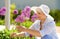 Senior woman with allium flowers at summer garden