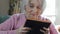 Senior Woman In Armchair At Home Looking At Photo Album