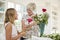 Senior woman arranging flowers with granddaughter at home