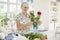 Senior woman arranging flowers at home