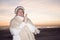 Senior woman on beach in winter hat and sweater