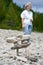 Senior woman behind Inukshuk statue on beach