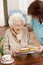 Senior Woman Being Served Meal