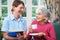 Senior Woman Being Visited By Carer At Home