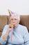 Senior Woman With Birthday Hat Blowing Noise Maker