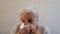 Senior woman blows her nose in a handkerchief.