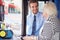 Senior Woman Boarding Bus And Buying Ticket