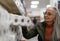 Senior woman buying toliet paper in supermarket.