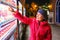 A Senior woman buys a bottle of water from a vending machine