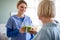 Senior woman with caregiver or healthcare worker indoors, drinking healthy smoothie.