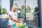 Senior woman with a cart filled with groceries in front of the supermarket