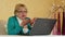 Senior woman communicates uses laptop. Woman with laptop