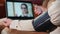 Senior woman consults doctor via webcam, measures blood pressure