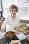 Senior woman cooking soup in kitchen