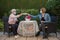 Senior woman and daughter having coffee at safety distance in the garden,