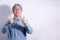 Senior woman in denim shirt on white studio background. Smiling elderly woman showing thumbs up