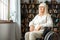 Senior woman with disability recovery at home wheelchair looking out the window