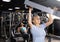 Senior woman doing lat pull-down on lever gym machine