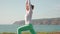 Senior woman doing yoga warrior pose ocean background