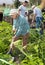 Senior woman is dripping potatoes in garden outdoor with family