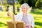 Senior woman with easel painting outdoors