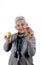 Senior woman eating apple on white