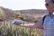 Senior woman enjoys outdoor using a drone. Background of mountain with cactus and sky