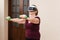 Senior woman exercising with dumbbells weights at home wearing VR glasses. Active elderly, fitness training, metaverse.