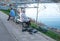 Senior woman feeds pigeons sitting on bench on embankment