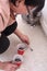 A senior woman fills a hole in the floor with cement. Cementing to repair damaged tiles