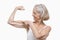 Senior woman flexing muscles against white background