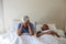 Senior woman getting disturbed with man snoring on bed