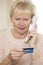 Senior Woman Giving Credit Card Details On The Phone