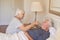 Senior woman giving medicine to her sick husband in bed