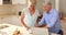 Senior woman giving tea to senior woman in kitchen