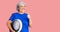 Senior woman with gray hair holding weight machine to balance weight loss smiling happy and positive, thumb up doing excellent and